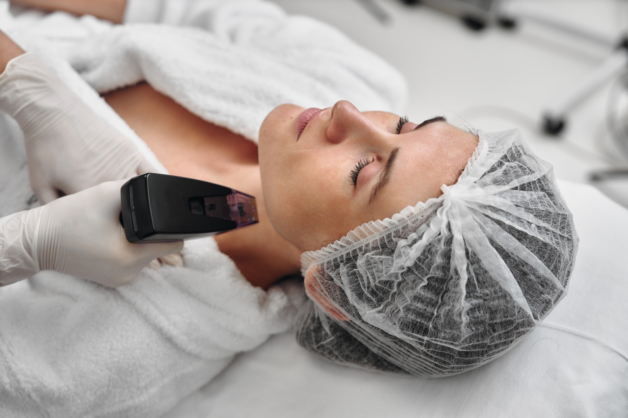 Woman receiving skin treatment at a spa in a bright, clean environment