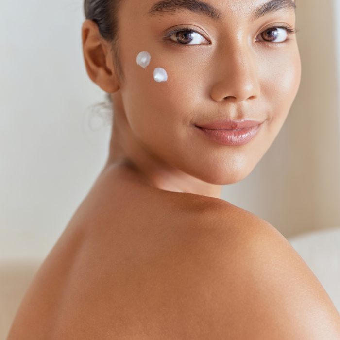 Natural Beauty. Woman Smiling With Skincare Cream On Face For Beauty Routine